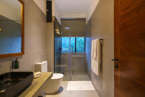 a bathroom with a shower and a toilet and a sink at Te Dalu Resort & Spa in Ella