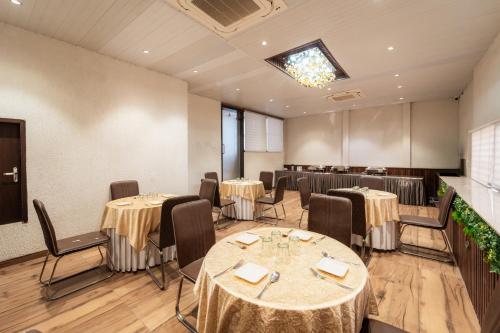 een eetkamer met tafels en stoelen en een tv bij Treebo Awadhvue in Indore