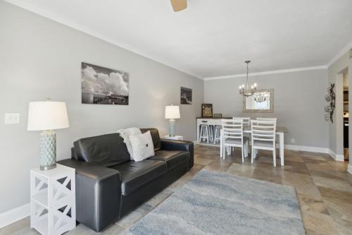 a living room with a black leather couch and a table at Tranquil Beach Retreat - Fernandina Shores 6398 in Fernandina Beach