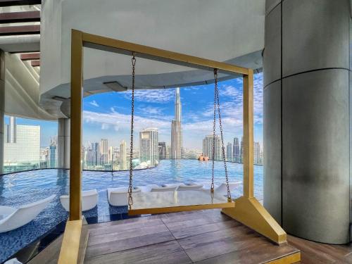 a swing in a room with a view of the city at Paramount Residences Dubai Apartments by BergStays in Dubai
