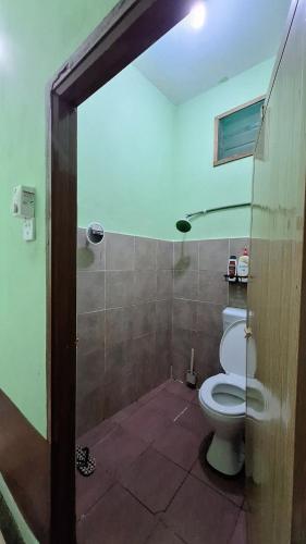 a bathroom with a white toilet in a room at The Nook Housestay in Ketereh