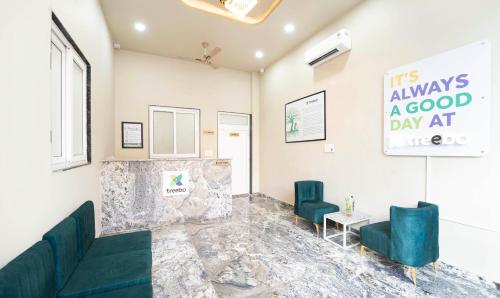 une salle d'attente avec deux chaises vertes et un panneau dans l'établissement Treebo Fort Mountview Jalmahal, à Jaipur