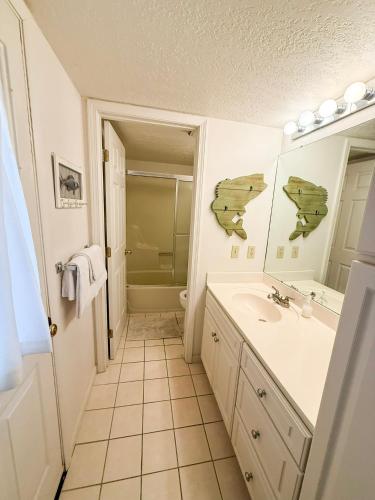 a white bathroom with a sink and a shower at Fins Up Margaritaville 2BD3BALoftGrillFirepit in Osage Beach