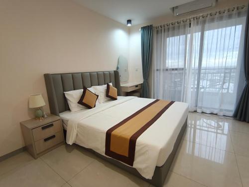 een slaapkamer met een groot bed en een raam bij Jian DaoBao in Phnom Penh
