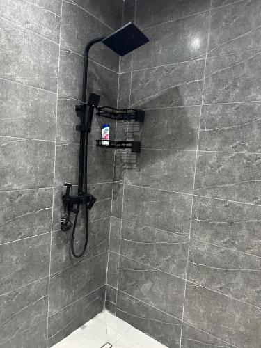 a shower with a shower head in a bathroom at Séjour Confort clim Navette Aéroport in Salé