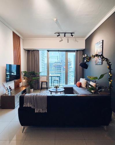 a living room with a couch and a tv at Dubai Marina Modern 1 Bedroom Apartment - steps to tram & Marina Walk in Dubai