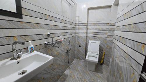 ein Badezimmer mit Waschbecken und Toilette in der Unterkunft Deoghar BnB in Deoghar