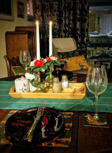 a table with a candle and a plate of food and glasses at Vintage vibe with modern conveniences - Sheffield & Peak District! in Stannington