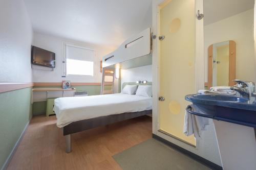 a hospital room with a bed and a sink at ibis budget Rennes Chantepie in Chantepie