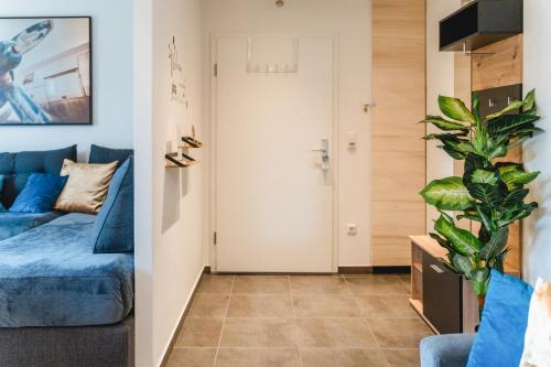 a living room with a blue couch and a plant at YAYstay - 58m2 - Bahnhof - Smart TV - Internet - Kaffee - Waschmaschine - Trockner in Mühldorf