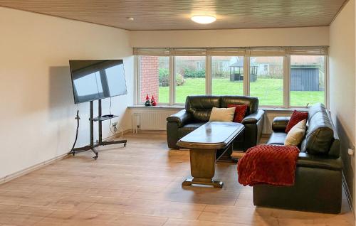 a living room with couches and a flat screen tv at 5 Bedroom Awesome Home In Lemvig in Nørby