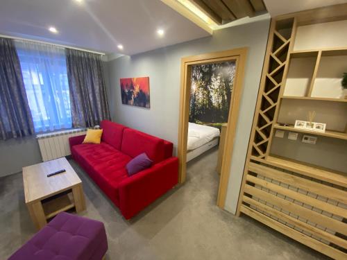 a living room with a red couch and a bunk bed at Hedonizam Jahorina 2 in Jahorina