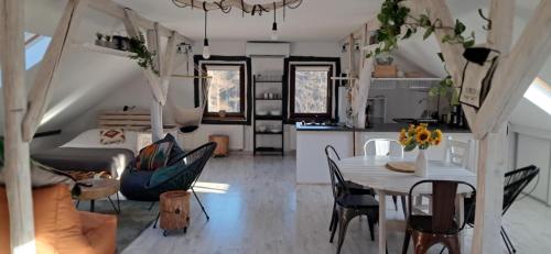 Małopolskie Swojskie في Olszyny: مطبخ وغرفة معيشة مع طاولة وكراسي