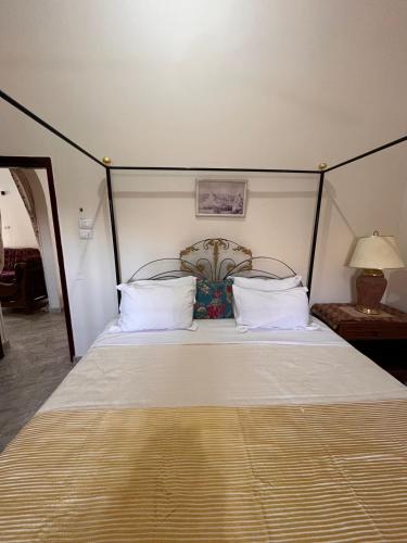 a bedroom with a large bed with white sheets and pillows at Abdalla's House in Al Aqālitah