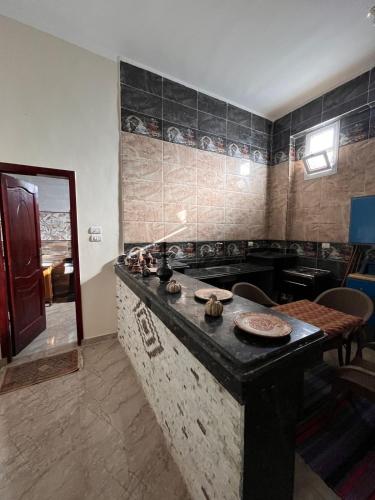 a kitchen with a stove and a counter top at Abdalla's House in Al Aqālitah
