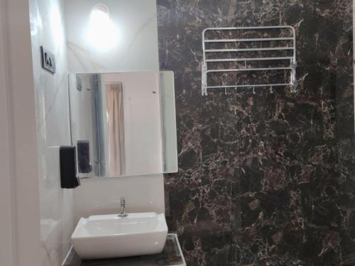 um banheiro com pia e espelho em Hare Krishna Beach Resort em Srīvardhan