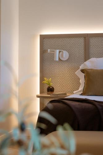 a bedroom with a bed with a headboard and a plant at Hotel Encinar de Sotogrande in Sotogrande