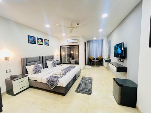 a bedroom with a large bed and a flat screen tv at Hotel Aroma - Chattarpur in Gurgaon