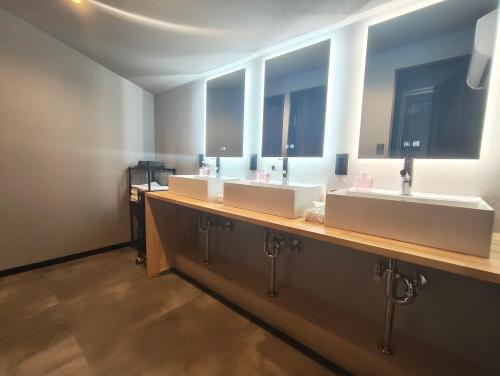 a bathroom with three sinks and two mirrors at Fukuchiya in Fujiyoshida