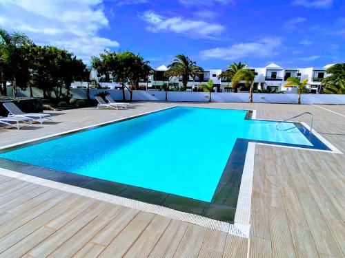 ein Swimmingpool mit blauem Wasser in einem Hof in der Unterkunft Luxury Senator Apartments in Costa Teguise