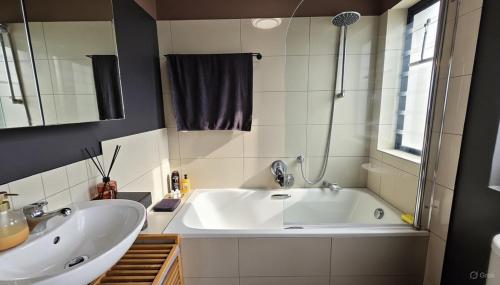 um banheiro com uma grande banheira branca e uma pia em Oceans Deep at Lagoon Terrace - Knysna! em Knysna