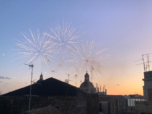 a group of fireworks in the sky over a city at HOMESTAY rooftop in Catania