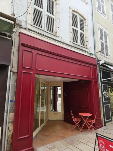 un edificio rojo con 2 sillas y una mesa en Fontaine - Centre - Wifi - Clim, en Dax