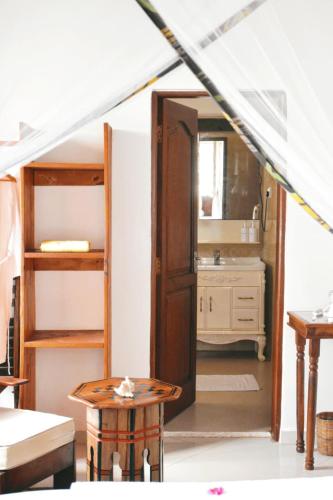 a room with a bunk bed and a bathroom with a sink at Habari House in Zanzibar City