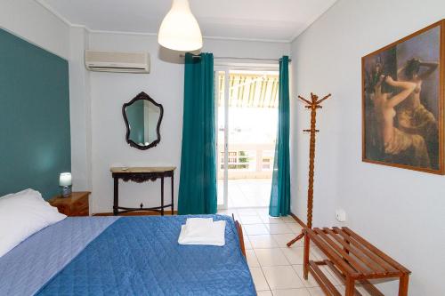 a bedroom with a blue bed and a window at Amadolia in Loutra Edipsou