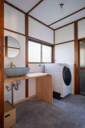 a bathroom with a sink and a washing machine at 空 Kuu in Odawara