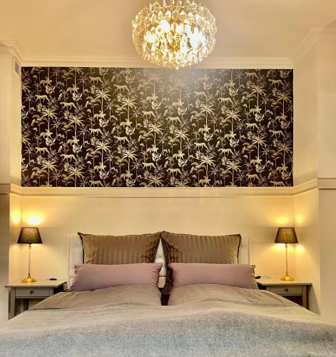 a bedroom with a bed with a black and white wallpaper at der Elbe so nah 2 in Dömitz