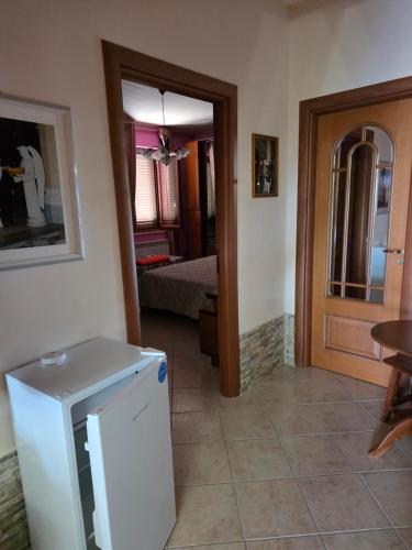 PERLA VERDE Rooms and parking في Case Nuove: مطبخ مع ثلاجة وغرفة مع سرير