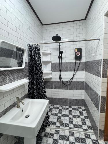 een badkamer met een wastafel en een douche bij Saensuk stay in Ban Wang Thong
