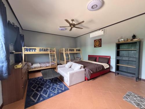 een slaapkamer met een bed en een plafondventilator bij Saensuk stay in Ban Wang Thong