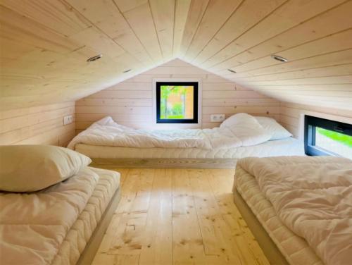 twee bedden in een kamer met een dak bij Cabane 3 étoiles - ccbechc in Neuilly-sur-Marne