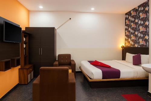 a hotel room with a bed and a tv and a chair at Hotel Heaven Stay in Shankerpalli