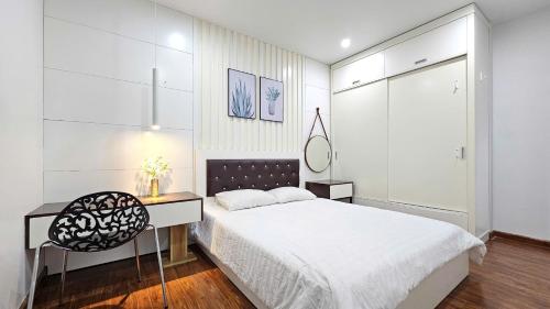 a bedroom with a bed and a desk and a chair at AnE House 1 - Spacious 2BR Apartment 69m2 - SHP Plaza - Hai Phong City Center in Hai Phong
