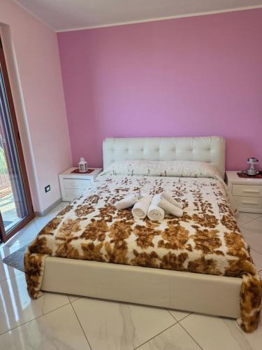 PERLA VERDE Rooms and parking في Case Nuove: غرفة نوم عليها سرير وعليها حذان ابيض