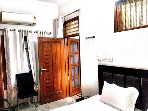 une chambre avec un lit et une porte en bois dans l'établissement Hotel Golden Time, à Karnal