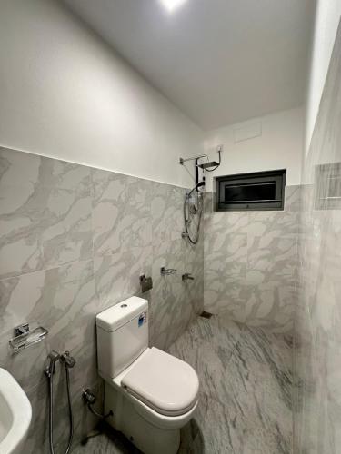 un baño con inodoro y lavabo en Villa 95 Hiriketiya, en Dikwella