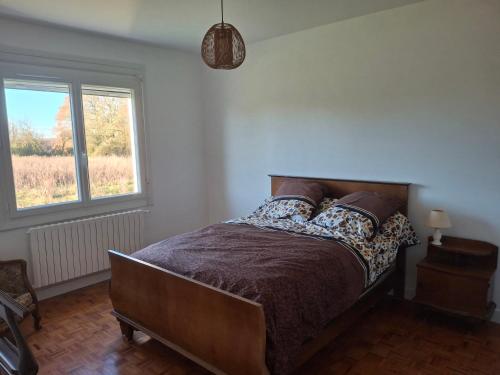a bedroom with a bed and a window at Maison BERDOT in Sévignac-Thèze