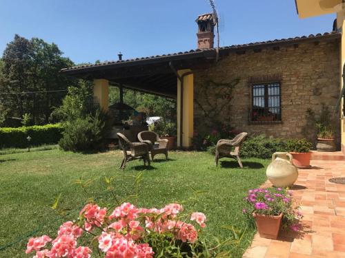 a yard with chairs and flowers in front of a house at Il cotogno in Carrosio