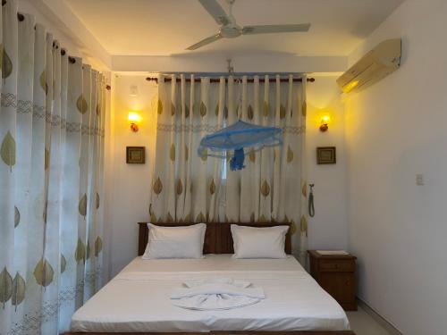 a bedroom with a bed with two towels on it at JJ Villa & Tours in Aluthgama