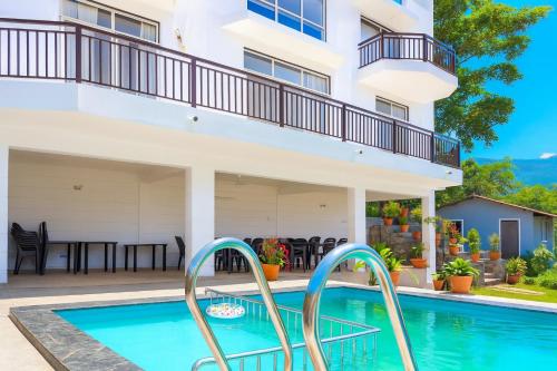 KolvanにあるHemgiri - 6BHK Pool Garden Luxury Villa Girivan Mulshi near Pune Mumbaiのバルコニー付きの家の前のスイミングプール