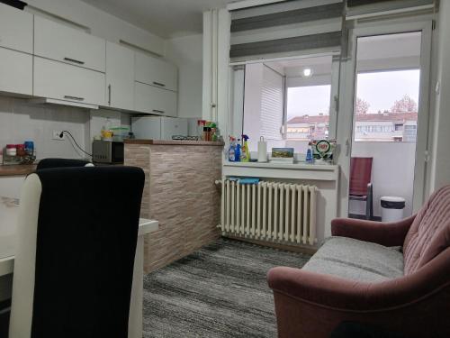 a living room with two chairs and a kitchen at Novi Priboj in Čitluk