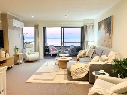 una sala de estar con un sofá y una mesa en Luxury Oceanfront Unit - Cumberland Lorne Resort, en Lorne