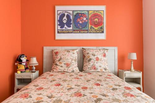 ein Schlafzimmer mit einem Bett mit einer orangefarbenen Wand in der Unterkunft Appartement immersif - ambiance série TV in Saint-Étienne