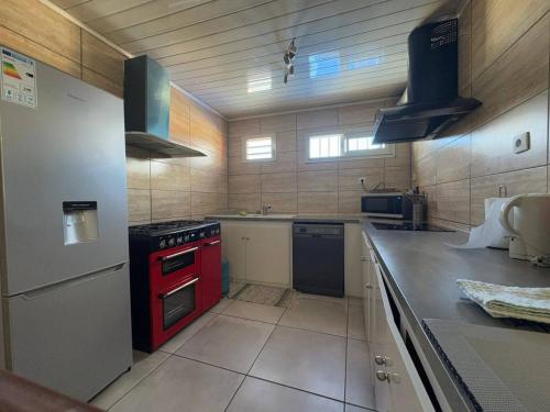 a large kitchen with a red stove top oven at L'Etape du Bonheur in Cilaos