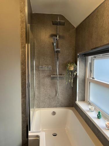 a bathroom with a tub and a shower at Morpeth, Northumberland home in Morpeth