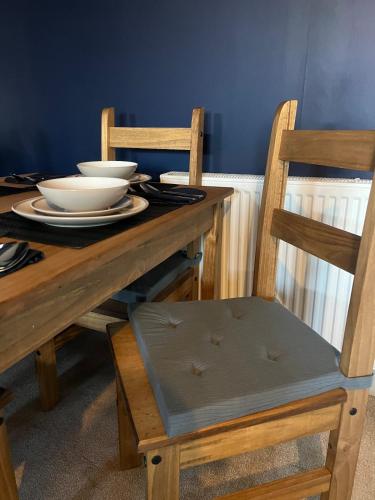 a wooden table with bowls and plates on it at Morpeth, Northumberland home in Morpeth